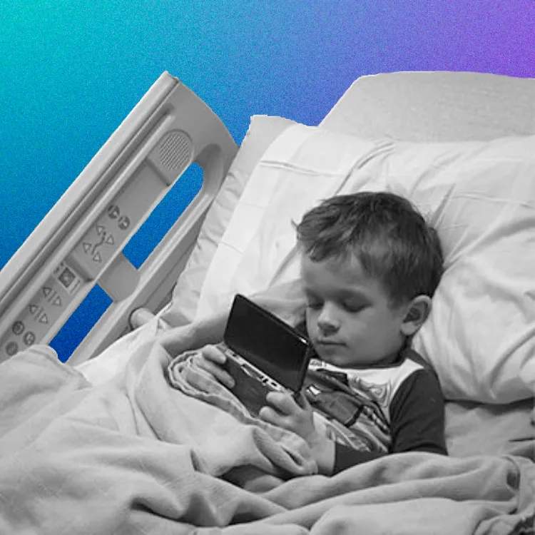 Young boy in hospital bed, playing a video game