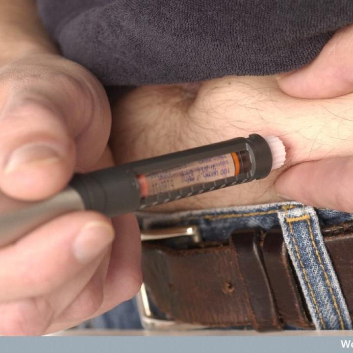 A diabetic injects himself using an insulin pen